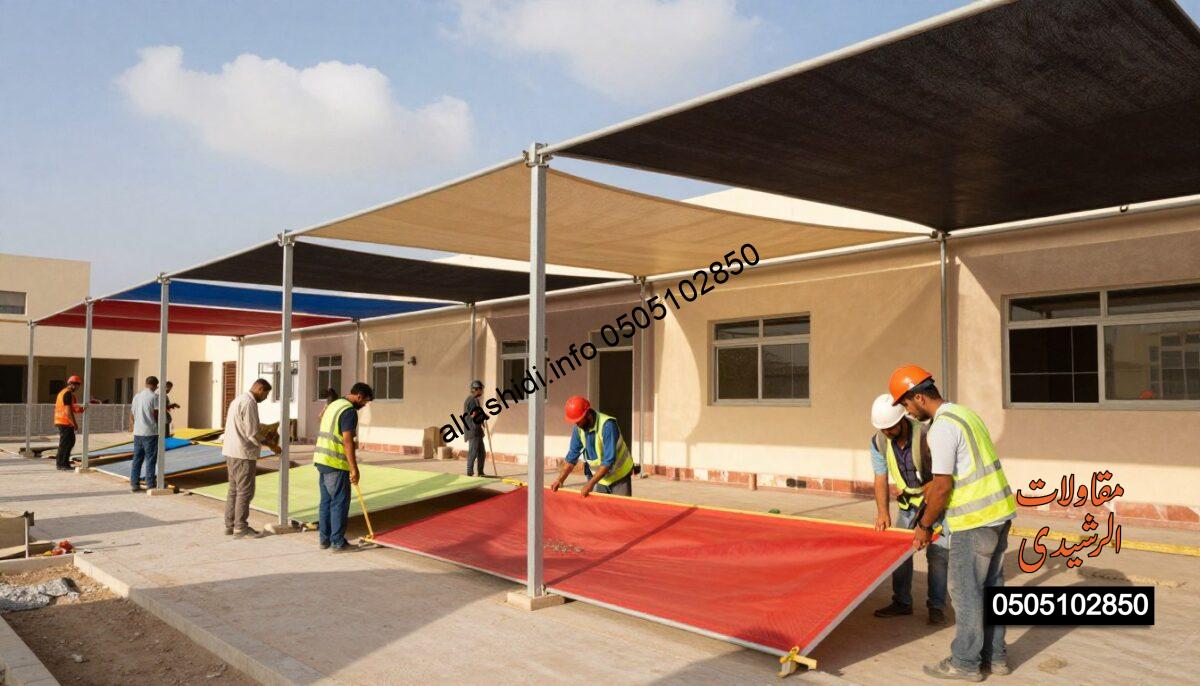 A realistic construction scene depicting workers installing high-quality shades over a schoolyard in West Riyadh. In the foreground, a diverse group of workers, dressed in professional safety gear, is meticulously measuring and securing vibrant, durable materials for the shades. The middle ground showcases partially completed shade structures, highlighting various fabric colors, textures, and installation techniques that emphasize quality assurance. The background features a clear blue sky with a few fluffy clouds, and a modern school building is visible. Soft sunlight casts natural shadows, creating a warm and inviting atmosphere that reflects dedication to excellence in material selection. Ensure a focus on professionalism and attention to detail throughout the image.