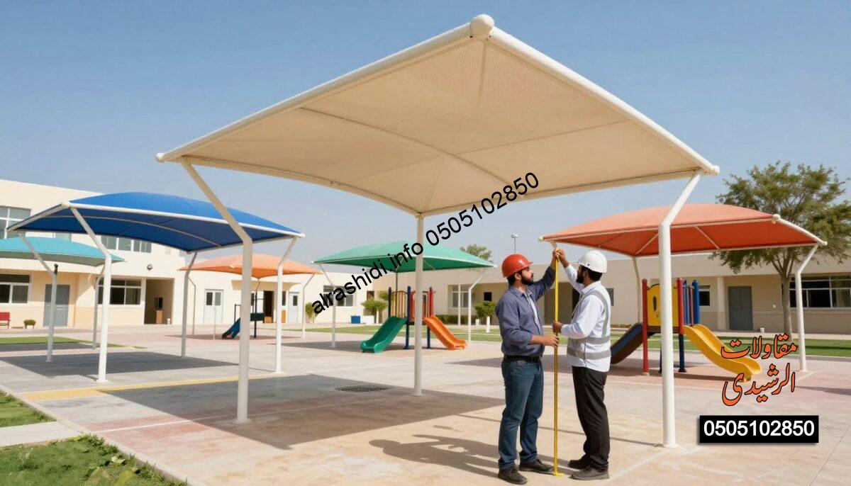 A realistic construction scene depicting workers installing school canopies in West Riyadh. In the foreground, two workers in professional business attire are carefully measuring and positioning a large shade structure over a playground area, emphasizing safety and professionalism. In the middle ground, various colorful school canopies are visible, showcasing different styles and materials, under a bright blue sky. The background includes a modern school building with a welcoming atmosphere, surrounded by greenery and a few trees. Bright, natural lighting enhances the scene, creating an optimistic mood. The camera angle is slightly elevated, offering a wide view that captures the overall installation process without any text or branding elements. The environment conveys a sense of community and quality in educational infrastructure.
