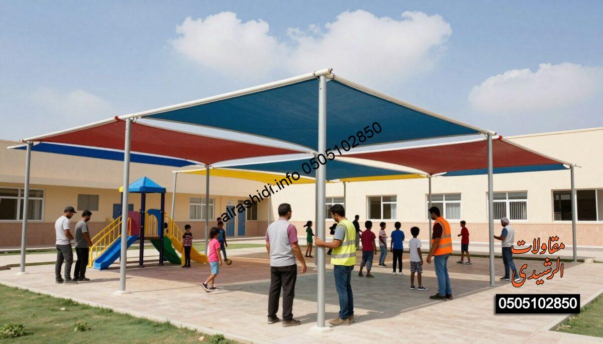A vibrant, realistic construction scene showcasing the advantages of school shades in a schoolyard setting in Riyadh. In the foreground, skilled workers, dressed in professional attire, are installing large, colorful canopies over playground areas to provide shade and protection for students. In the middle ground, children can be seen playing safely under the shade, highlighting the benefits of sun protection. The background features a clear blue sky with a few fluffy clouds, casting gentle natural light on the scene. The composition emphasizes safety, comfort, and the lively atmosphere of a school environment, with bright colors reflecting the joy of outdoor activities. The angle captures the dynamic teamwork of the installation process, creating an engaging and informative image.