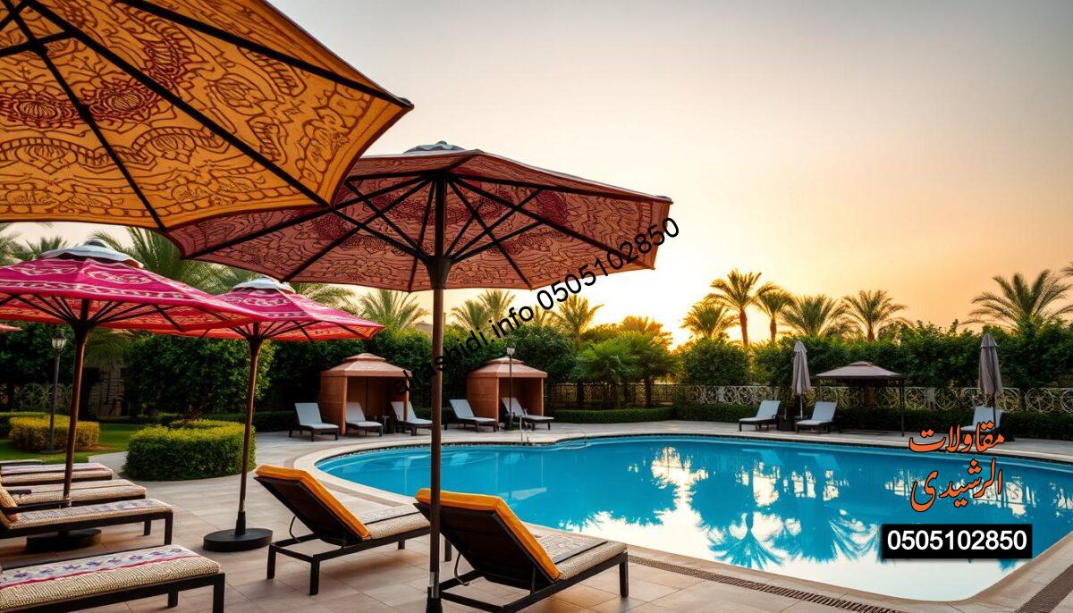 A vibrant outdoor scene showcasing high-quality pool umbrellas placed around a luxurious swimming pool in Riyadh, designed for gardens and recreation areas. In the foreground, several colorful and stylish umbrellas provide shade, each displaying intricate fabric patterns that highlight durability and elegance. The middle ground features a sparkling blue pool, surrounded by lush greenery and elegant lounge chairs, inviting relaxation. In the background, the sun is setting, casting a warm, golden light over the scene, which enhances the tranquility and allure of the environment. The overall atmosphere is serene and inviting, emphasizing quality craftsmanship and the enjoyable outdoor experience. The angle is slightly elevated, capturing the fullness of the setting while highlighting the umbrellas' design. No text, watermarks, or human figures are present in the image.